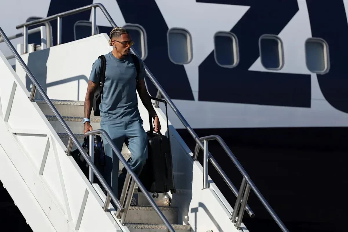 Player disembarking from airplane with luggage