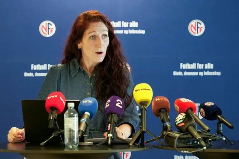 Official speaking at press conference with microphones