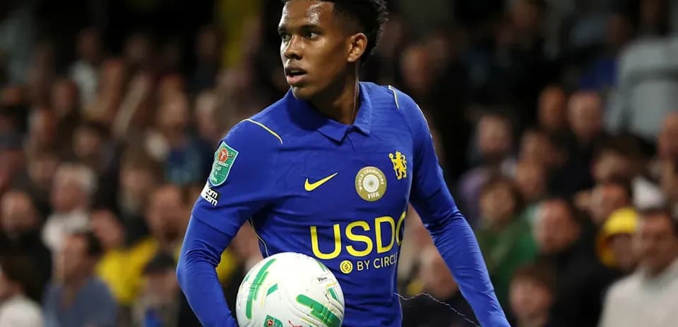 Player in blue jersey holding a football during match