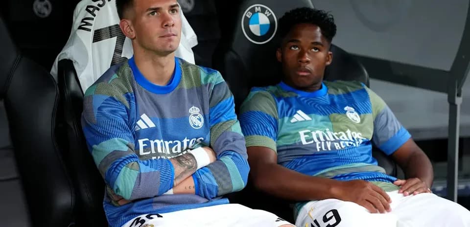 Two Real Madrid players seated on bench during match