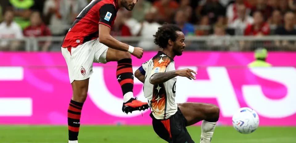 AC Milan player kicking ball against Venezia opponent