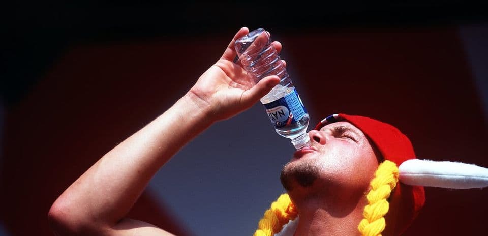 Person drinking water from a bottle during event