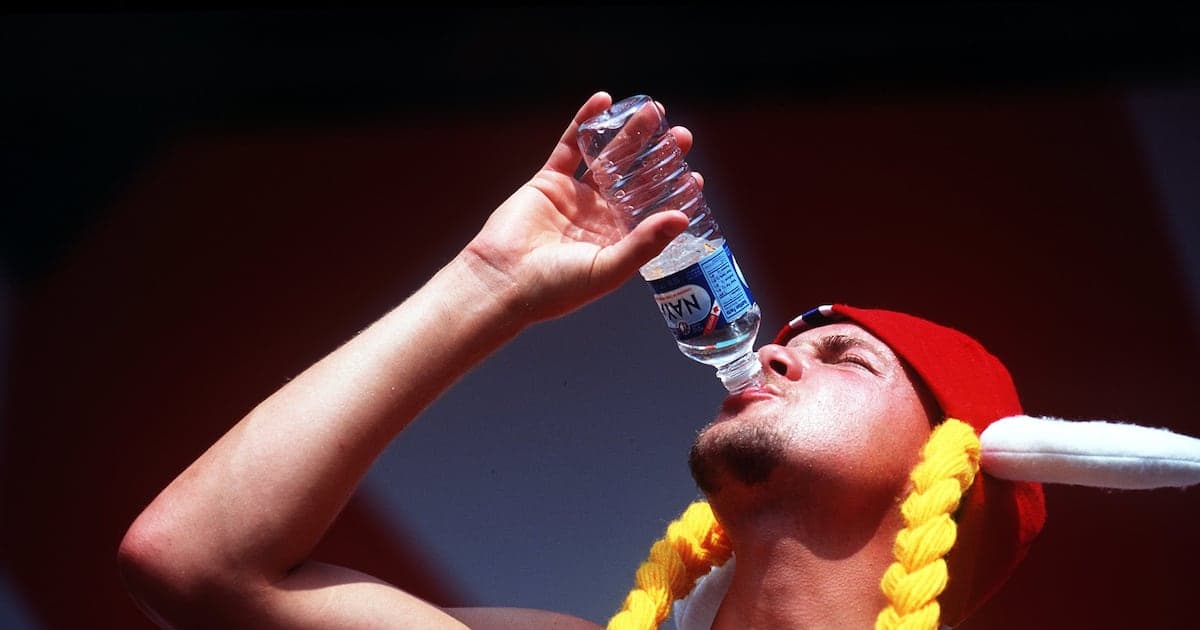 Person drinking water from a bottle during event