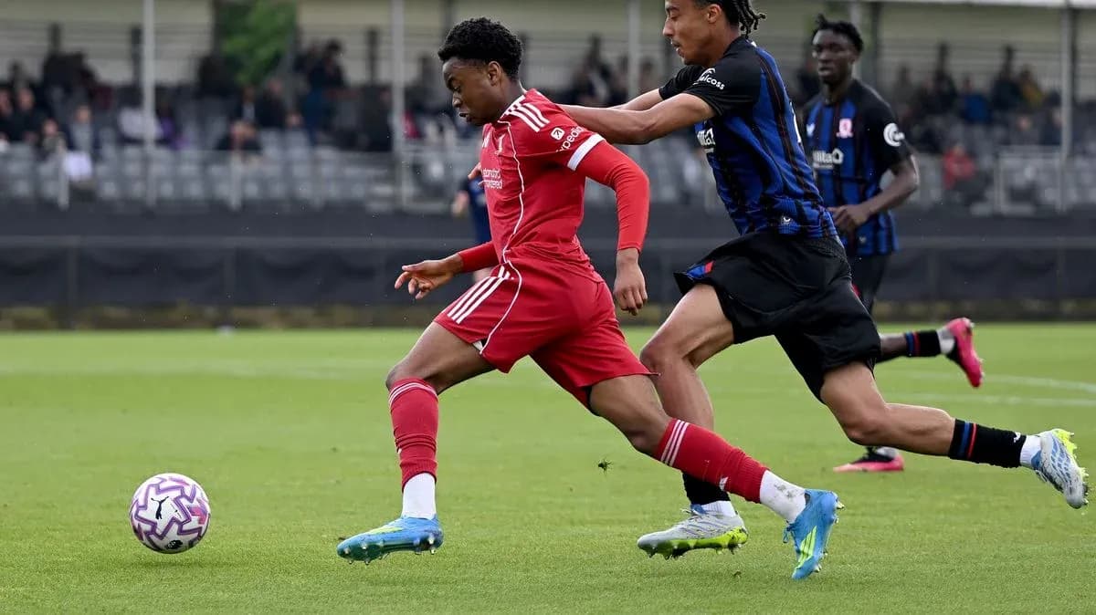 Player in red dribbling while being challenged by opponent