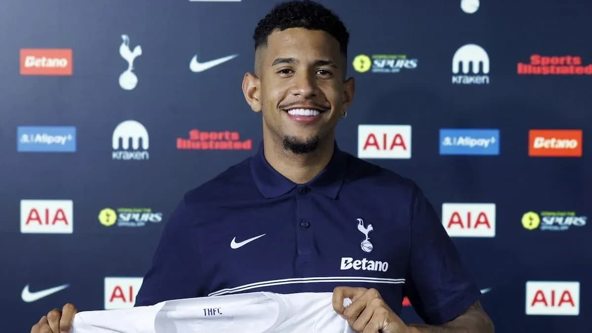 Player holding Tottenham Hotspur jersey at press conference