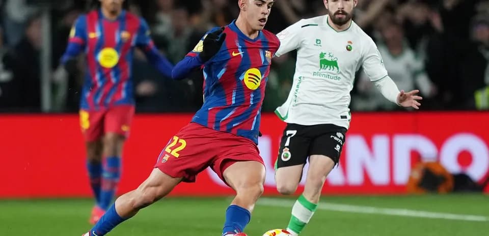 Barcelona player dribbling against Racing Santander