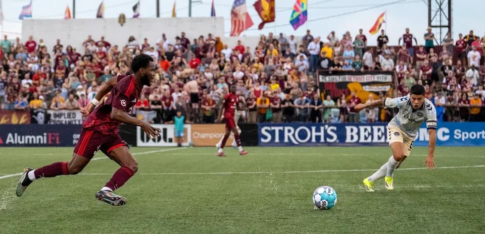 Players chasing the ball during Detroit City match