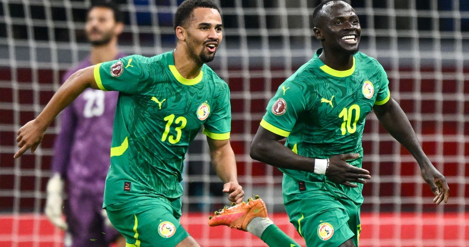 Two Senegal players celebrating a goal on field
