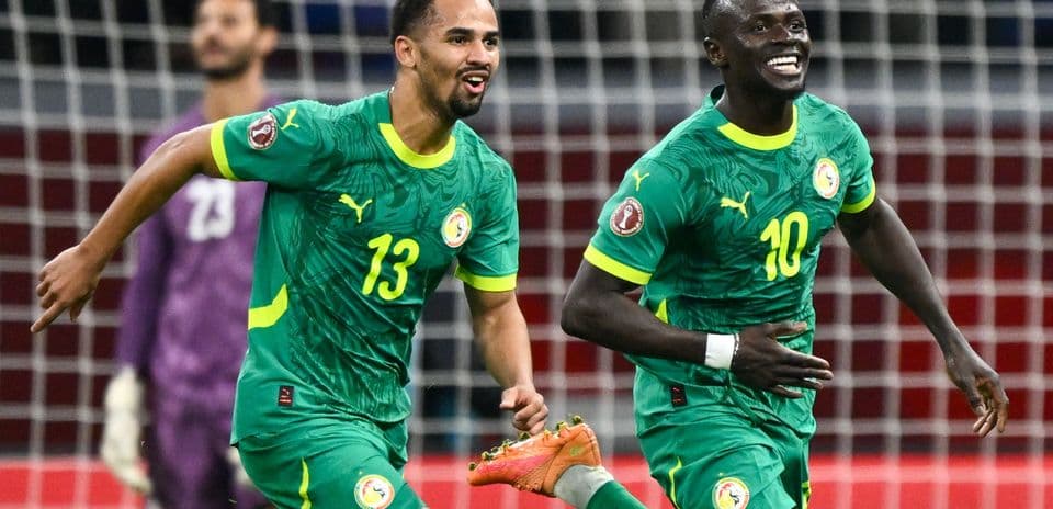 Two Senegal players celebrating a goal on field
