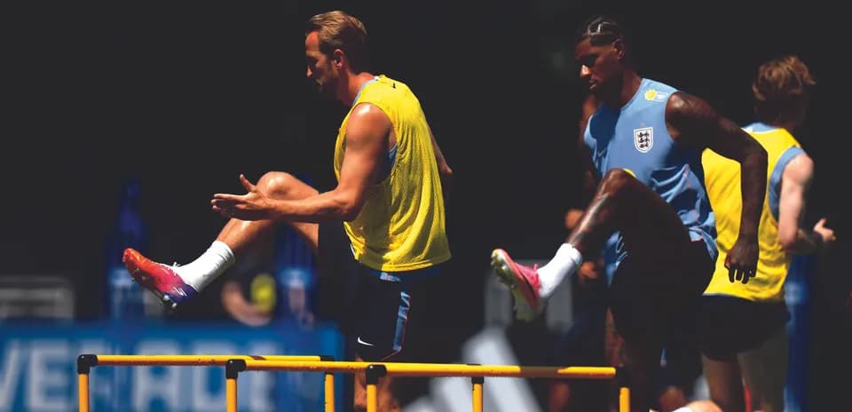 Players training by jumping over hurdles in practice