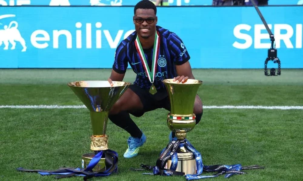 Player celebrating with two trophies on the field