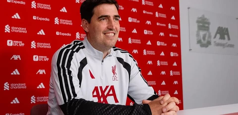 Coach speaking at Liverpool press conference table