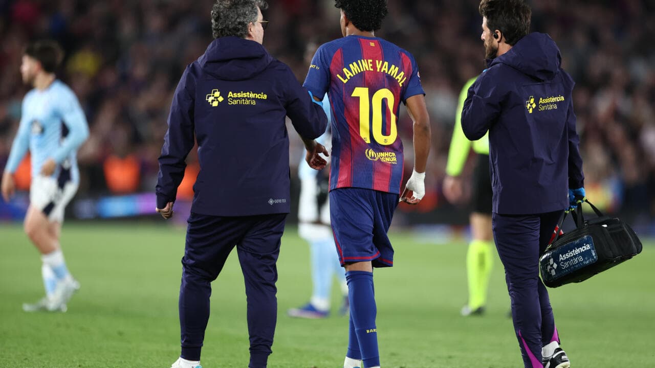Lamine Yamal being assisted off the field by staff