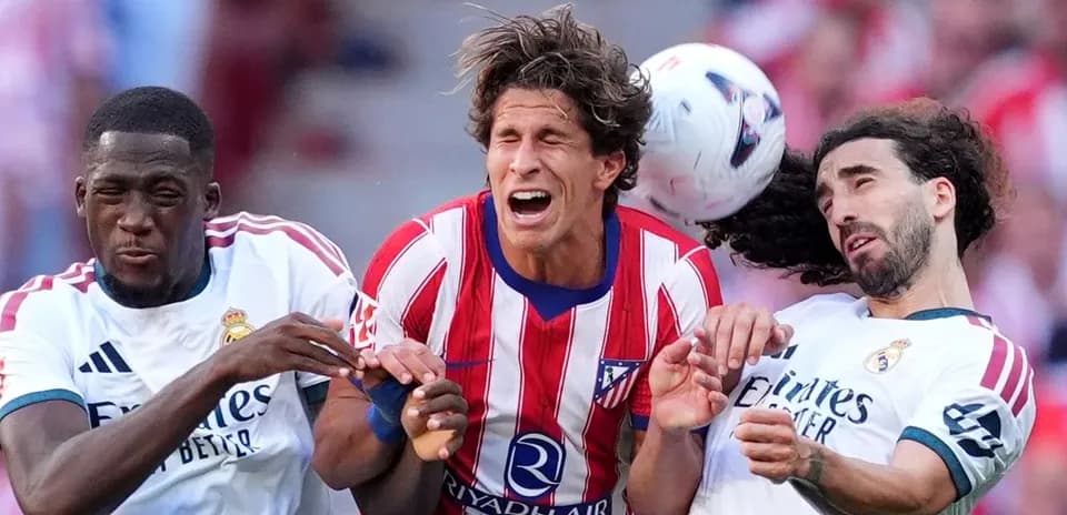 Players from Atlético and Real Madrid contesting for the ball