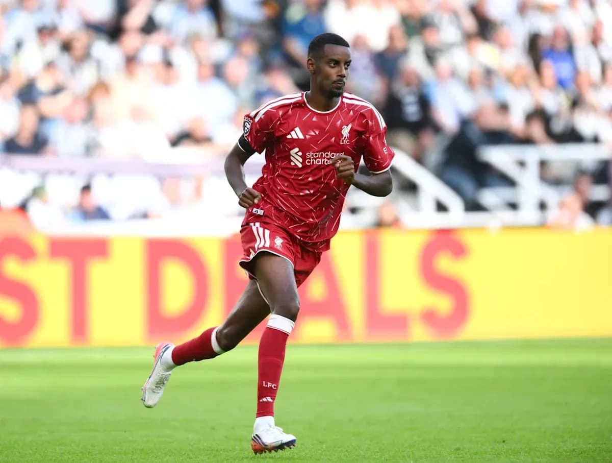 Player running in red Liverpool kit on field