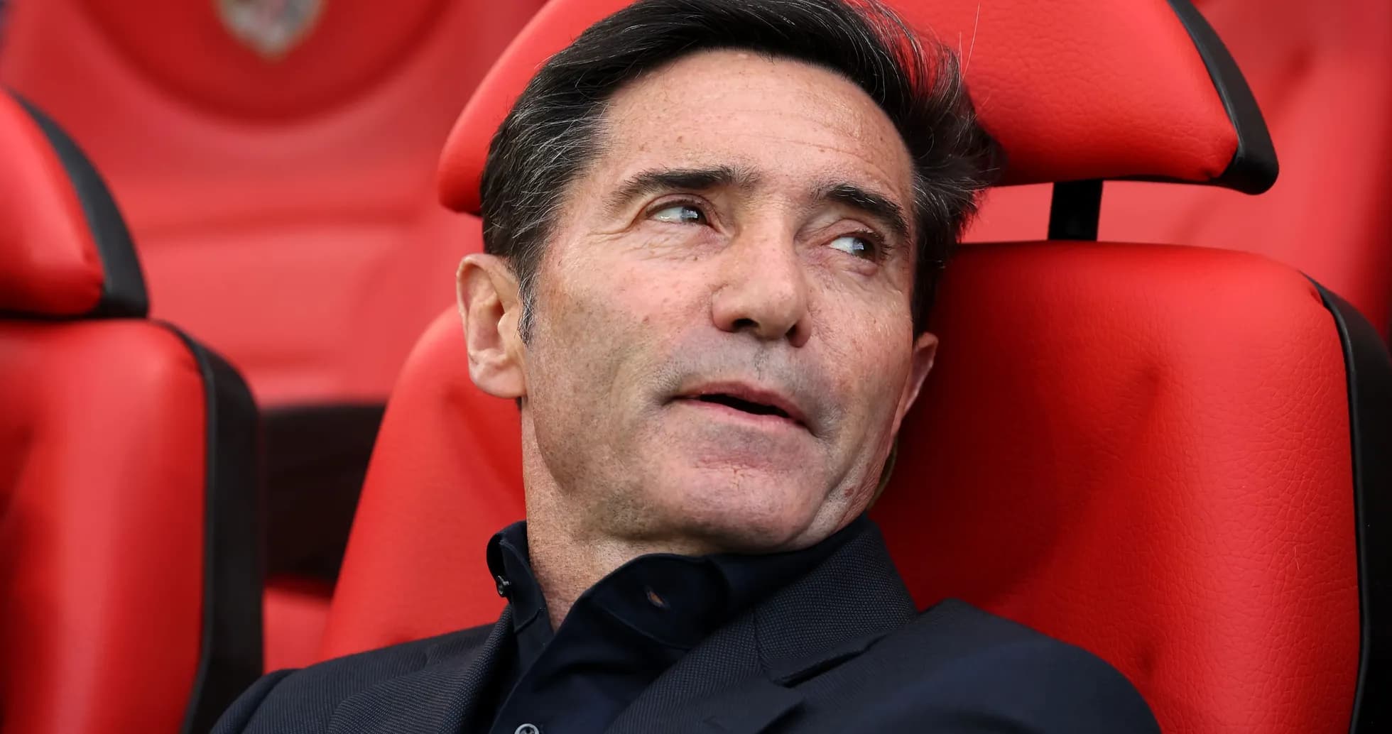 Coach seated on bench during a match