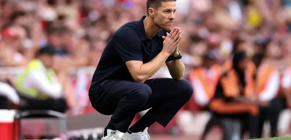 Coach observing the game while crouching on the sidelines
