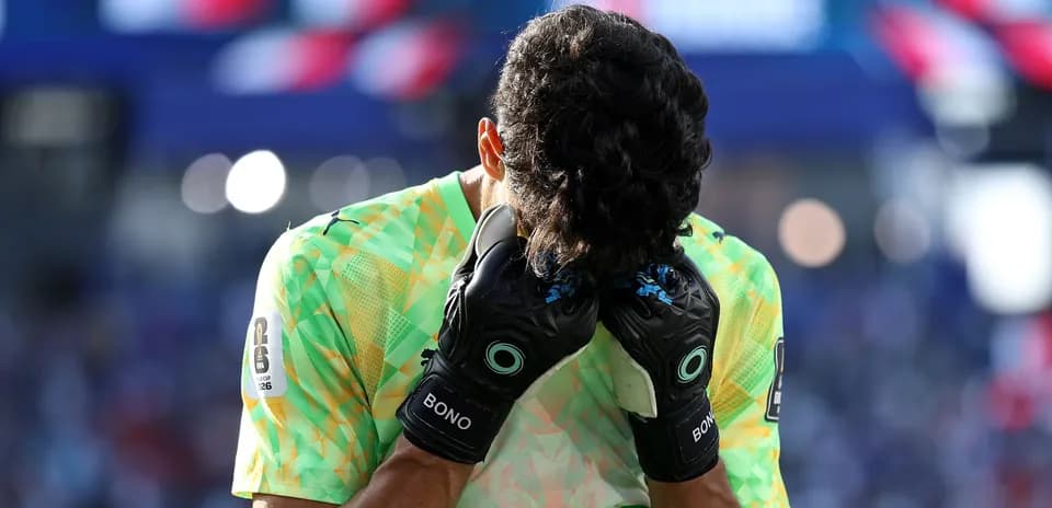 Goalkeeper holding head with gloves during match