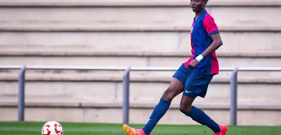 Player in Barcelona kit controlling the ball on field