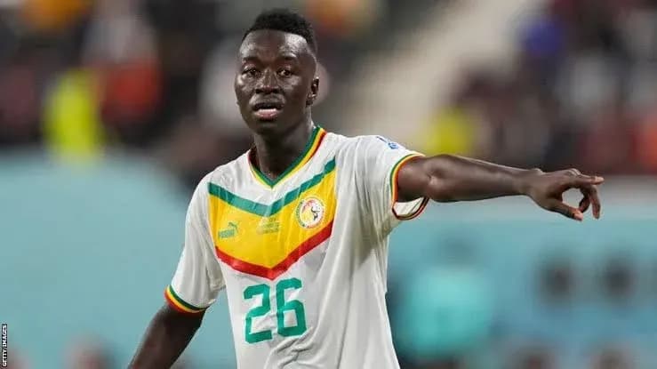 Player in Senegal national team jersey directing on field