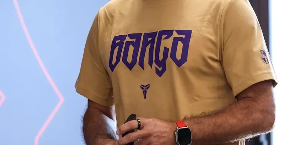Coach holding a water bottle and phone indoors