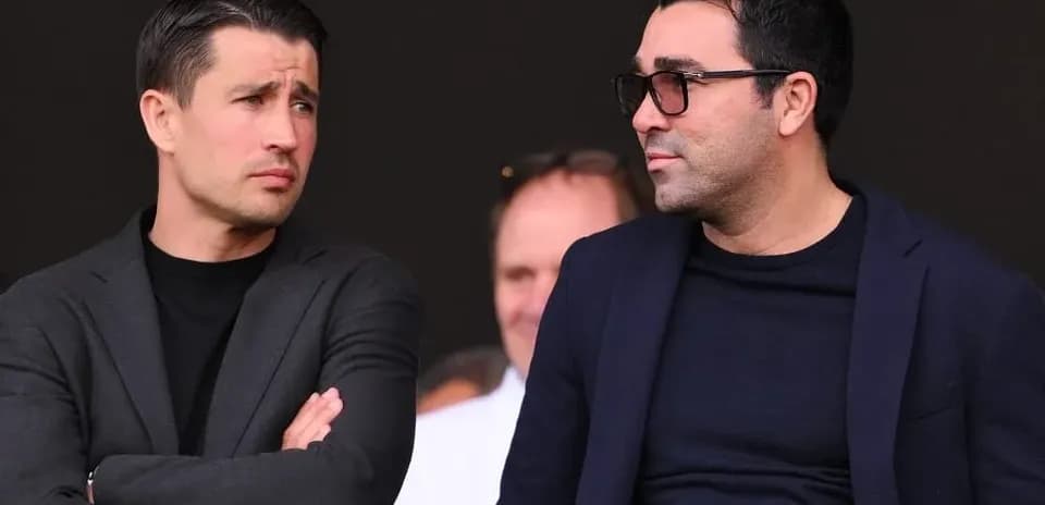 Two men talking in a stadium setting
