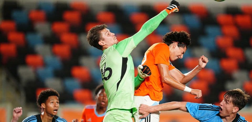 Goalkeeper punches the ball during match action