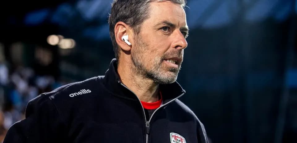 Coach wearing earbuds, focused on the game