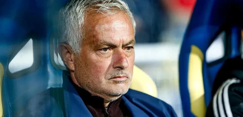 Manager seated on bench during a match