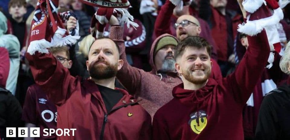 Fans celebrating with scarves in stadium crowd