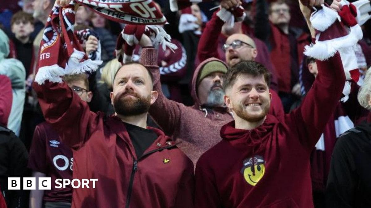 Fans celebrating with scarves in stadium crowd