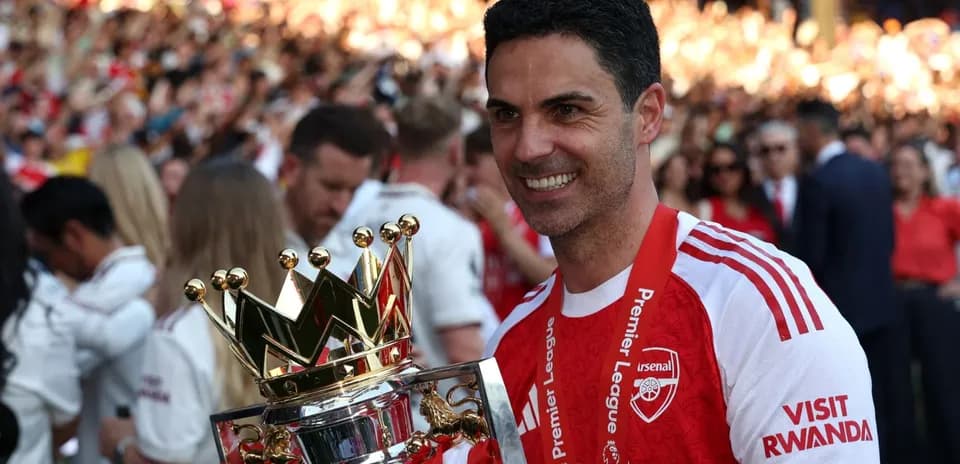 Arsenal manager holding Premier League trophy during celebration