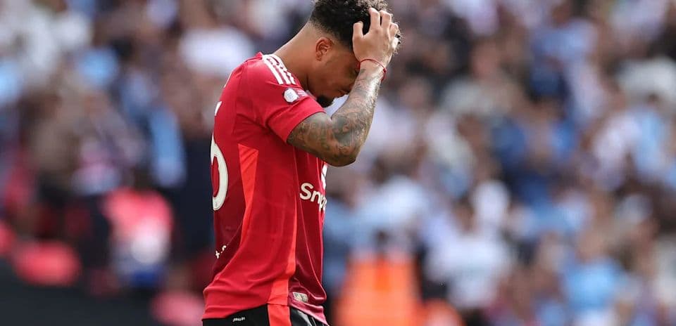 Player in red jersey holding head down during match