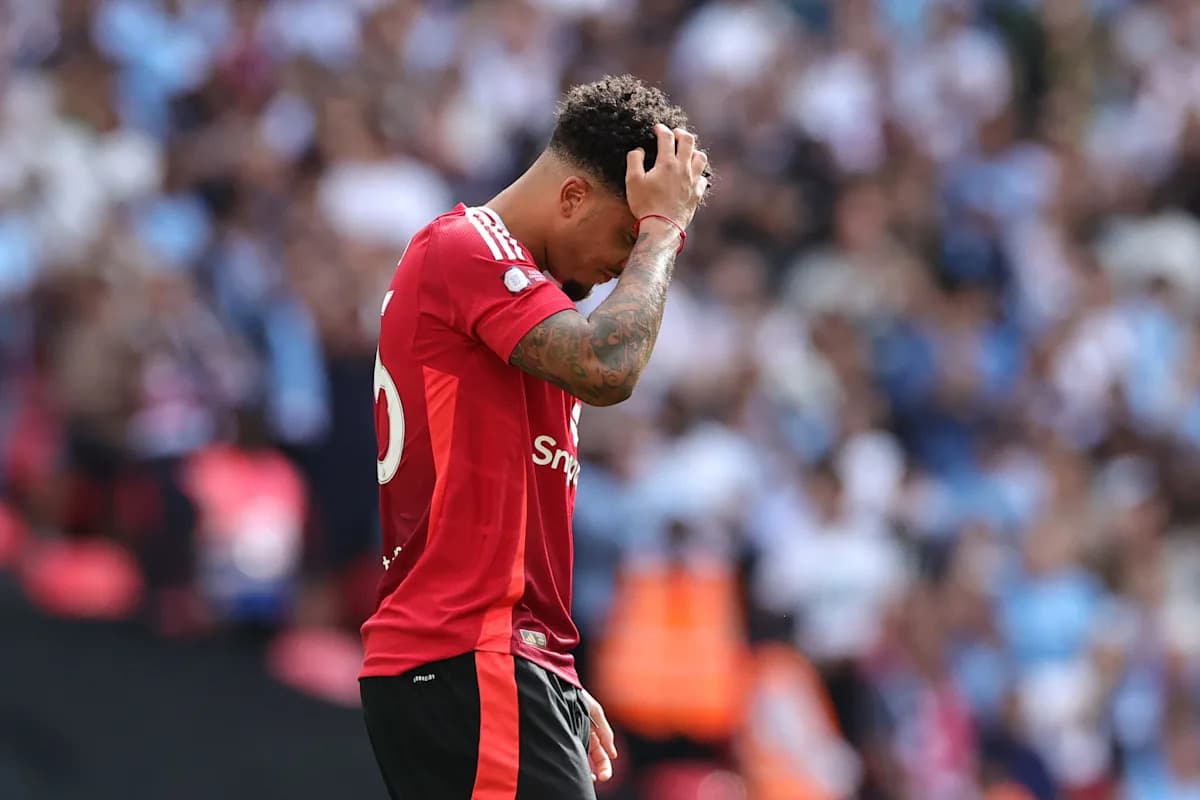 Player in red jersey holding head down during match