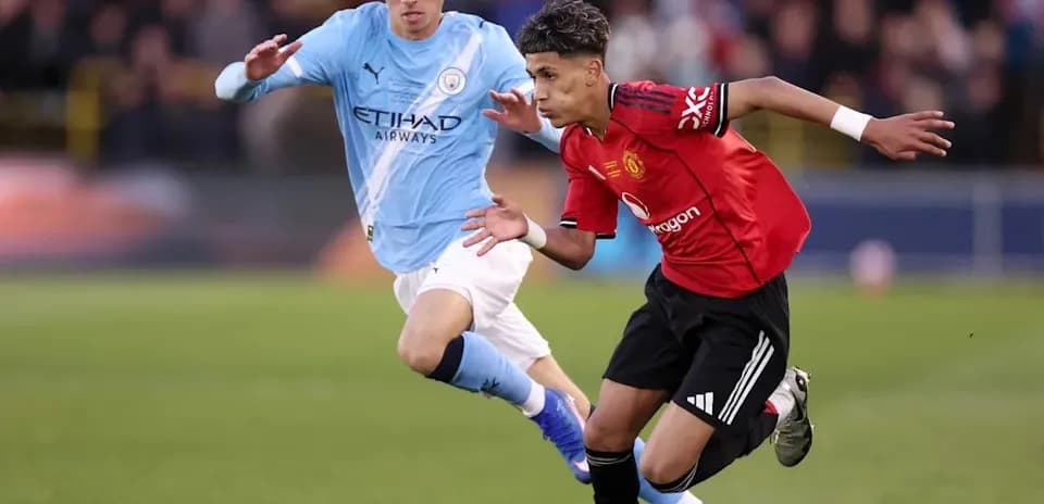Player from Manchester United dribbling past Manchester City opponent
