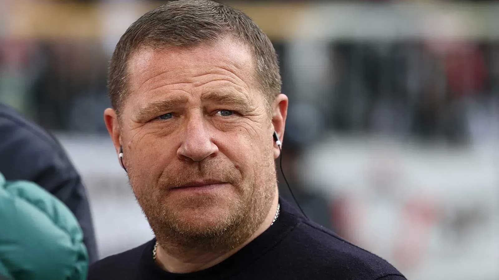 Man wearing headphones, looking serious outdoors
