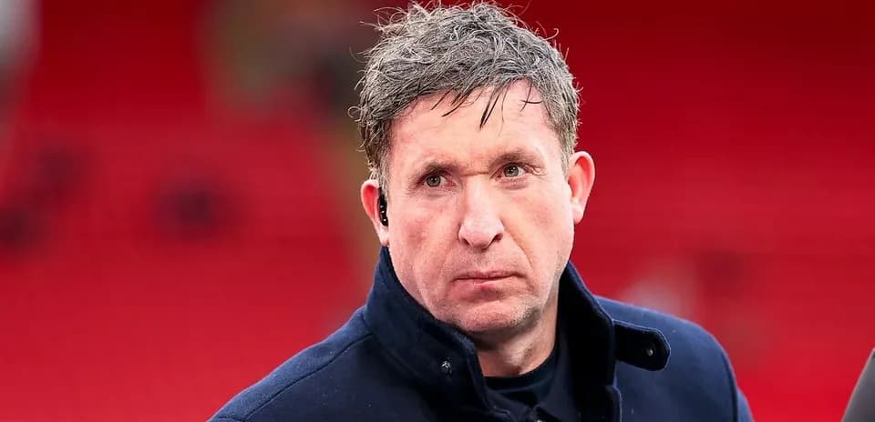 Man in a dark coat at a stadium
