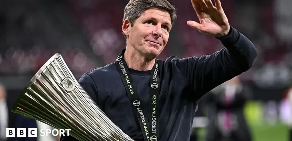 Coach holding trophy and waving after match