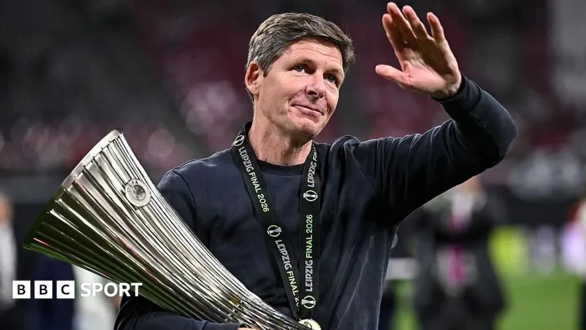 Coach holding trophy and waving after match