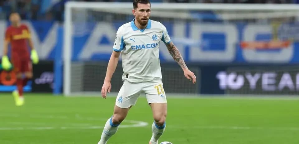 Player in white kit dribbling ball on field