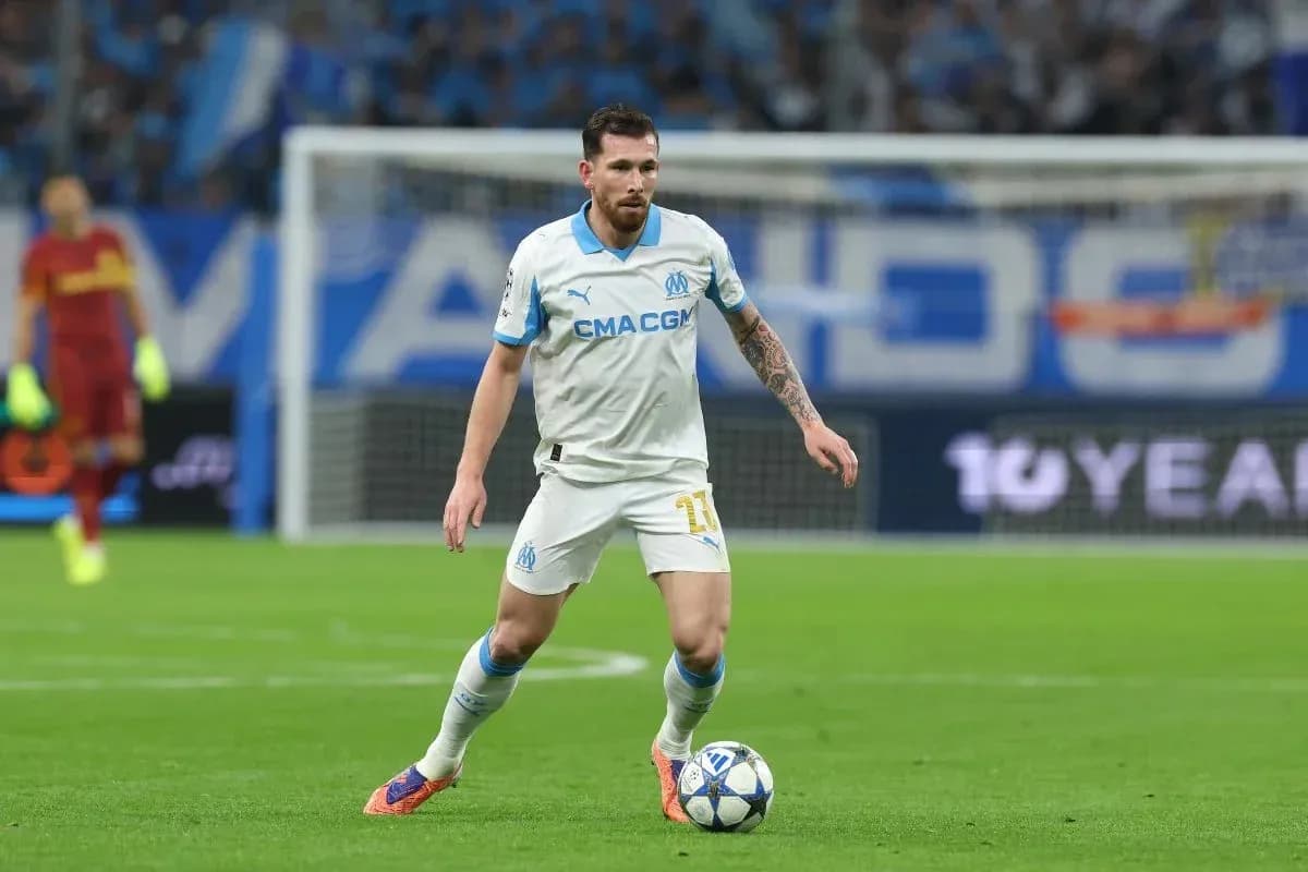 Player in white kit dribbling ball on field