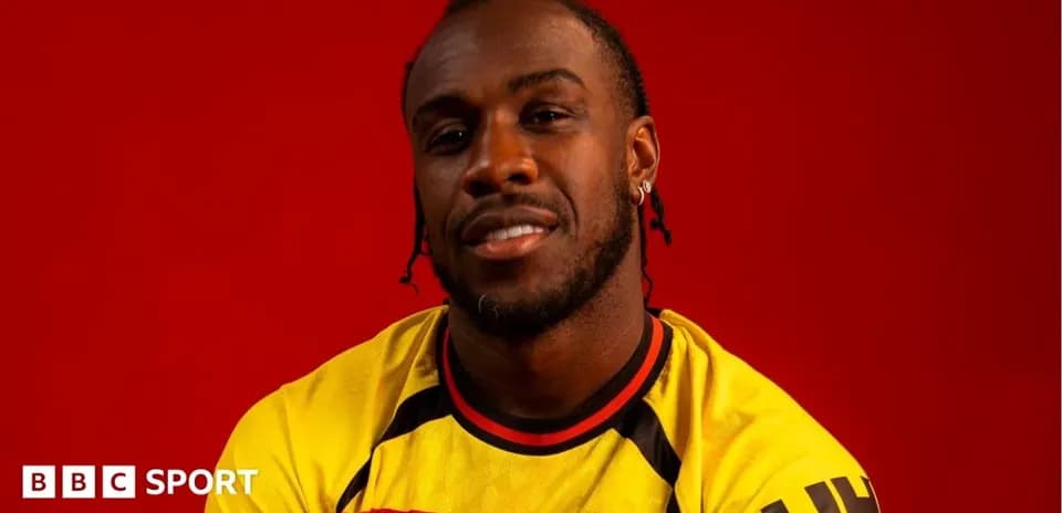 Player posing in Watford jersey against red background
