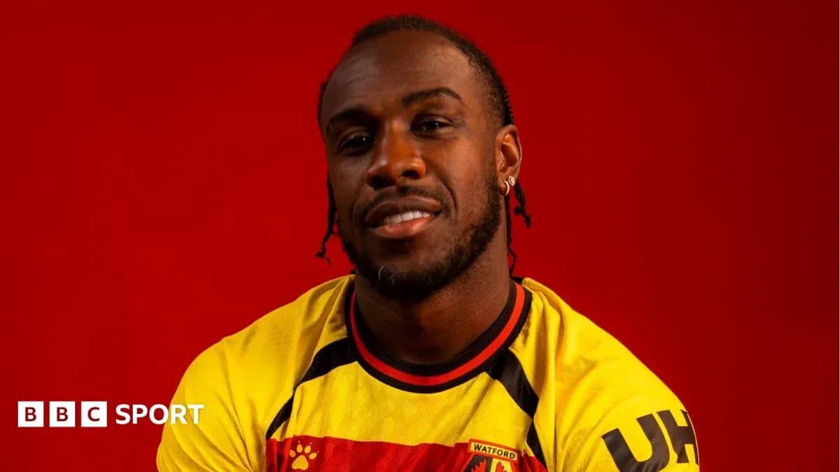 Player posing in Watford jersey against red background