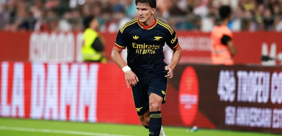 Player in Arsenal kit running with the ball
