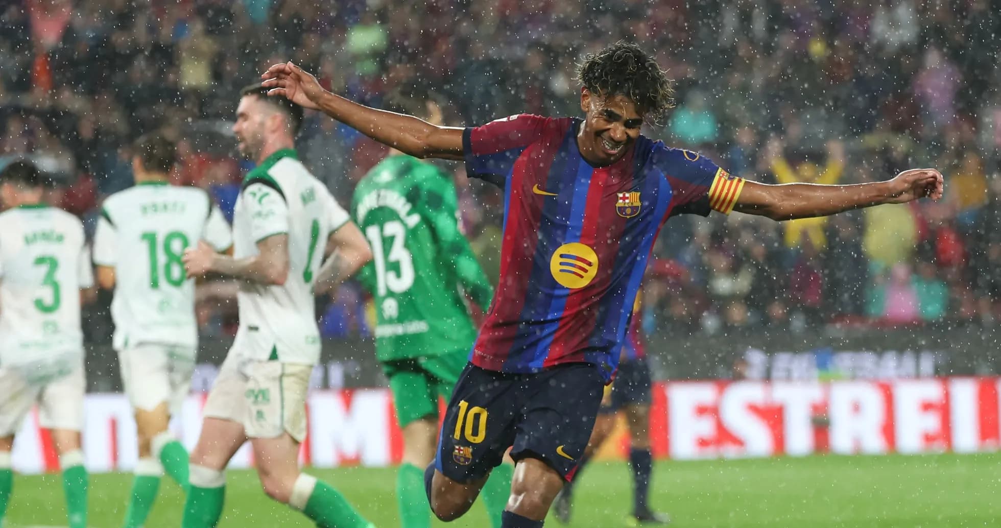 Player celebrating a goal in heavy rain