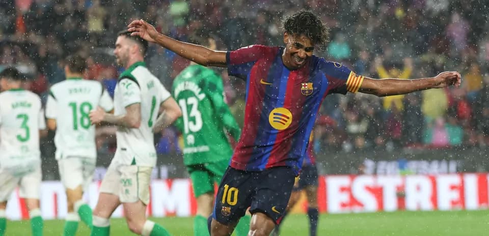 Player celebrating a goal in heavy rain
