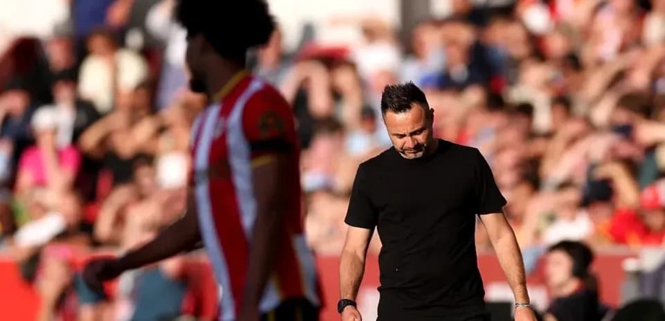 Manager walking past player during a match