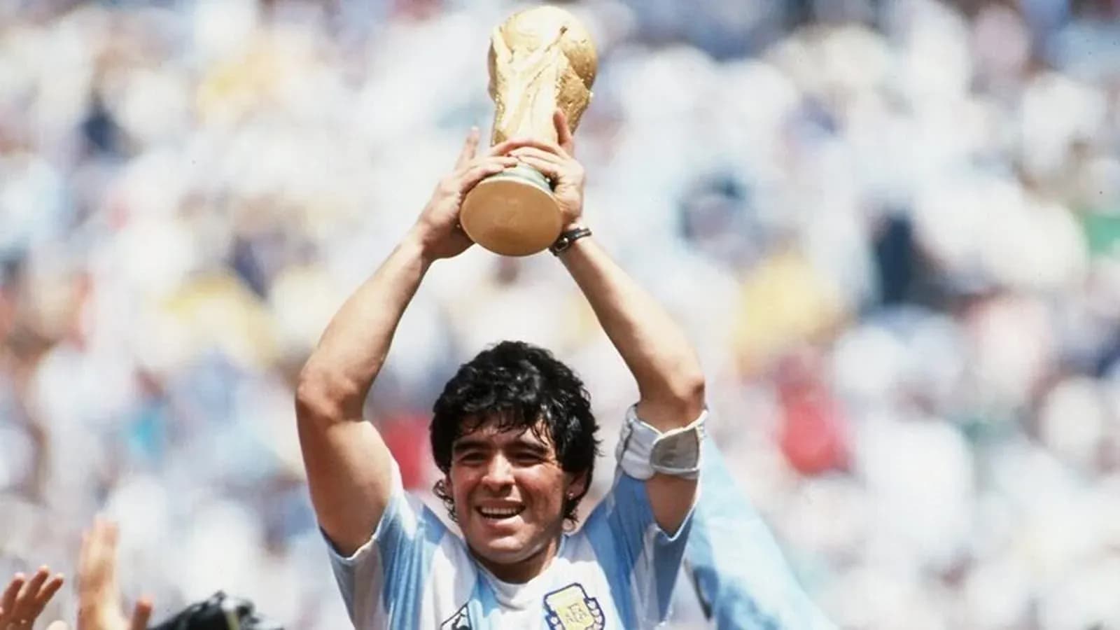 Player celebrating with World Cup trophy raised high