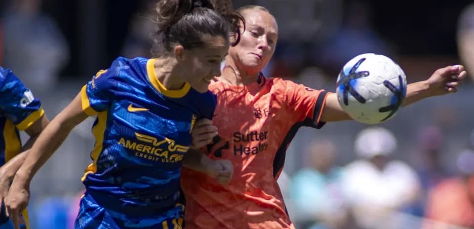 Two players competing for the ball in NWSL match