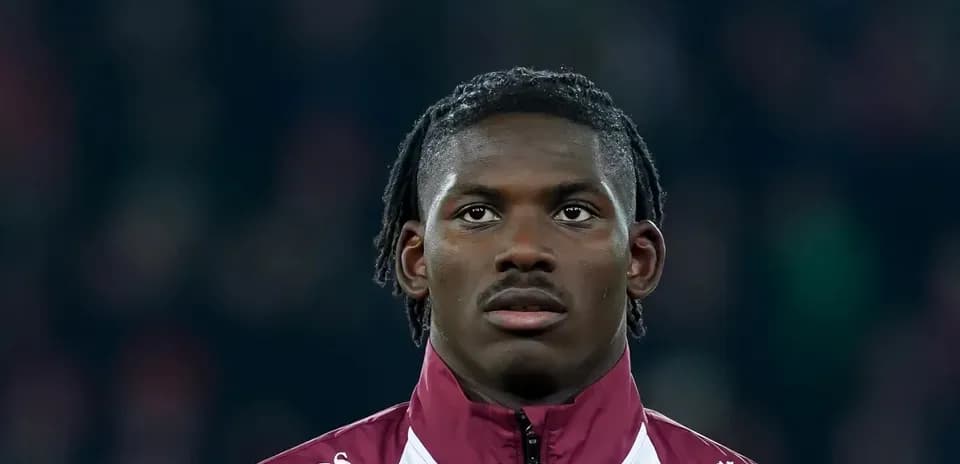 Player wearing a maroon jacket during match warm-up